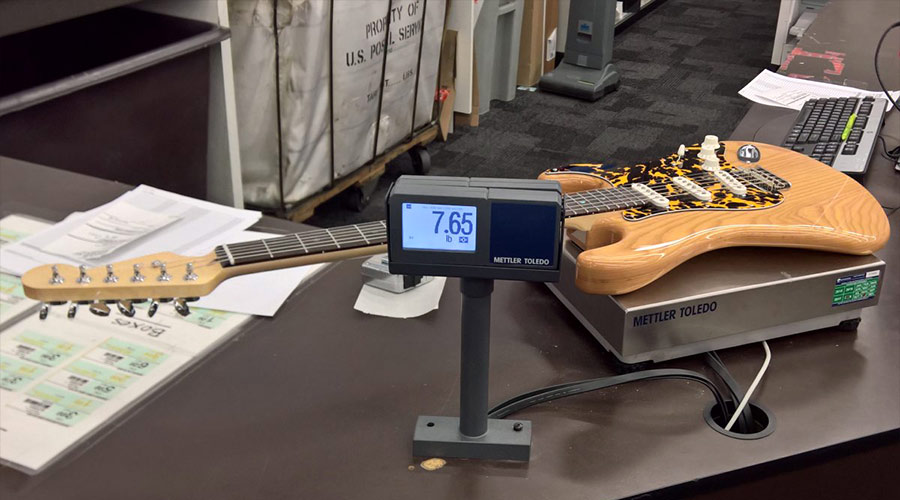 Stratocaster guitar on a weight scale.
