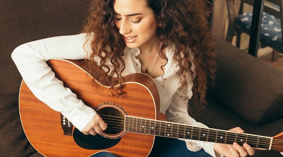 Open D chords on guitar being played by lady